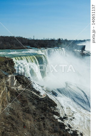 Water flows over Niagara Falls in early spring, showcasing the natural beauty and power of the waterfalls on a clear day Water flows over Niagara Falls in early spring, showcasing the natural beauty and power of the waterfalls on a clear day 140651137