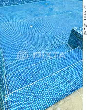 Swimming pool area with blue tiles and steps leading into water at a leisure location during midday Swimming pool area with blue tiles and steps leading into water at a leisure location during midday 140651240