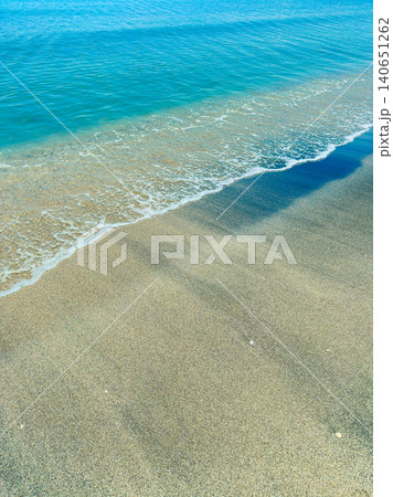 Waves wash onto sandy shore at clear ocean during bright sunny day at midday Waves wash onto sandy shore at clear ocean during bright sunny day at midday 140651262