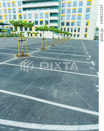 Newly designed parking lot with trees and modern building in urban area in daylight Newly designed parking lot with trees and modern building in urban area in daylight 140651287