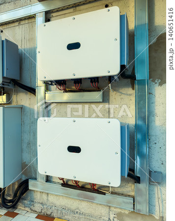 Solar power inverters mounted on a wall inside a building during afternoon hours, converting sunlight to electricity Solar power inverters mounted on a wall inside a building during afternoon hours, converting sunlight to electricity 140651416