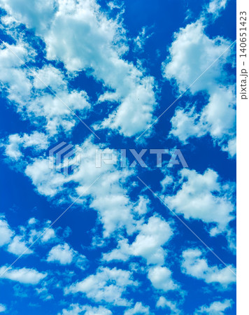 Clouds fill the sky during the day showing various shapes and patterns in a bright blue atmosphere Clouds fill the sky during the day showing various shapes and patterns in a bright blue atmosphere 140651423