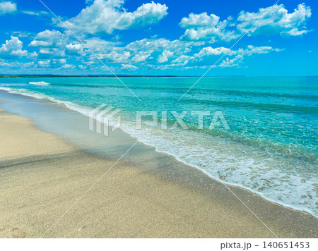 Waves gently washing up on a sandy beach under a blue sky filled with clouds during a sunny day Waves gently washing up on a sandy beach under a blue sky filled with clouds during a sunny day 140651453