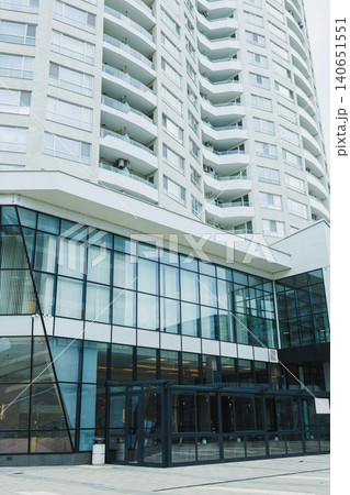 Modern building with glass facade and multiple floors located in an urban area during daylight hours Modern building with glass facade and multiple floors located in an urban area during daylight hours 140651551