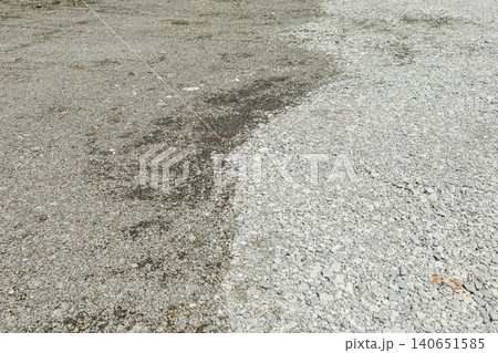 Gravel area shows wet and dry sections after rain in open space during the day 140651585