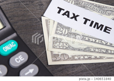 Calculator, inscription tax time, dollar banknotes. Calculating and paying tax for previous year Calculator, inscription tax time, dollar banknotes. Calculating and paying tax for previous year 140651840