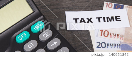 Calculator, inscription tax time and euro banknotes. Time of calculating, return or tax payment 140651842