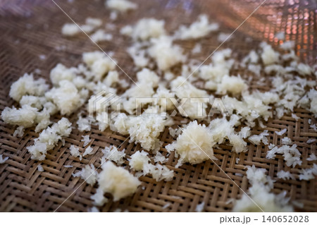 Cooked Sticky Rice Scattered on Woven Bamboo Tray Close-Up Cooked Sticky Rice Scattered on Woven Bamboo Tray Close-Up 140652028