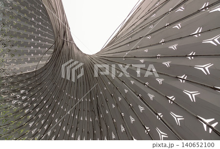 The composition of dominated by a sweeping arrangement of metallic, monochromatic ribs that converge and fan outward with the elegance of a bird wing. A prominent, sinuous curve divides the frame, The composition of dominated by a sweeping arrangement of metallic, monochromatic ribs that converge and fan outward with the elegance of a bird wing. A prominent, sinuous curve divides the frame, 140652100