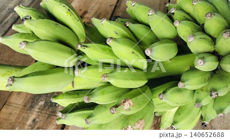 Fresh bunch of green bananas on a rustic wooden table background 140652688