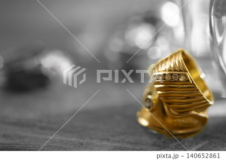 Elegant gold ring with diamonds on dark textured background 140652861
