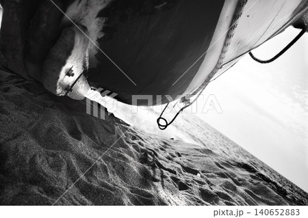 Monochrome boat hull close up on sandy beach with ocean view 140652883