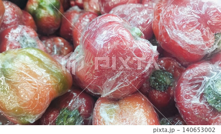 Fresh red bell peppers wrapped in plastic film background at supermarket 140653002