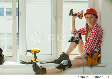 Woman with helmet next to the window Woman with helmet next to the window 140653083