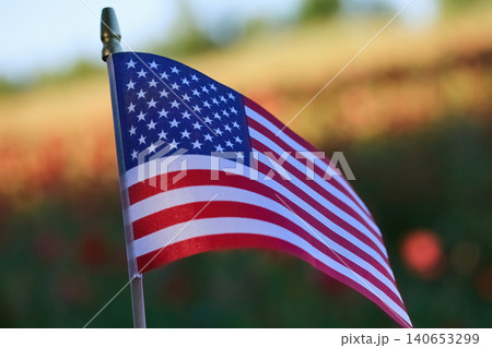 American flag waving in sunny poppy field representing patriotism 140653299
