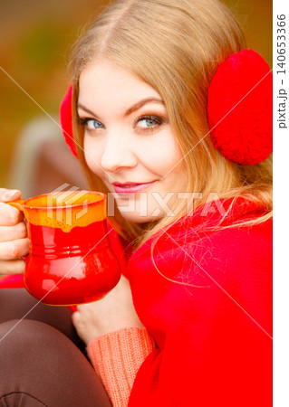 Girl in autumn park enjoying hot drink 140653366