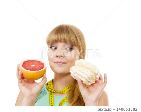 Woman choosing fruit or cake make dietary choice Woman choosing fruit or cake make dietary choice 140653382