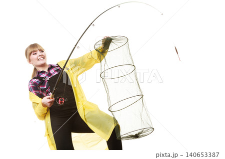 Happy woman holding fishing rod and keepnet Happy woman holding fishing rod and keepnet 140653387