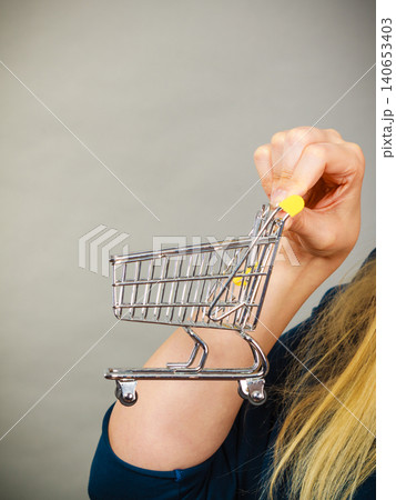 Woman hand holding small tiny shopping cart Woman hand holding small tiny shopping cart 140653403
