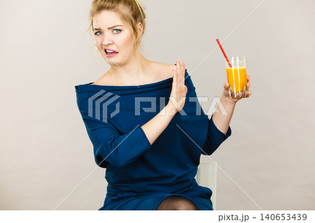 Disgusted woman holding orange juice 140653439