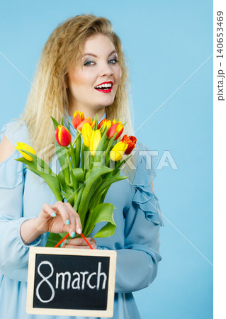 Woman holds tulips, board with text 8 march 140653469