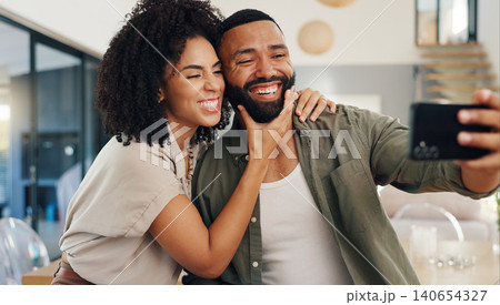 Home, selfie and couple with love, funny and smile with happiness and social media in a living room. Apartment, man and woman in a lounge, profile picture and humor with laughing and bonding together 140654327