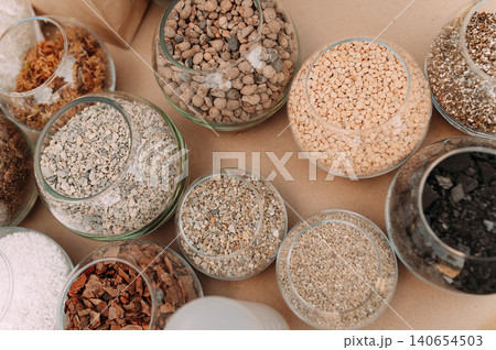 Natural soil substrates and drainage materials in glass jars for gardening, terrariums, succulents, and houseplants Natural soil substrates and drainage materials in glass jars for gardening, terrariums, succulents, and houseplants 140654503