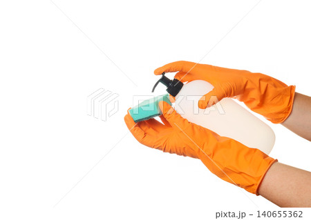 pressing the pump dispenser of a bottle to get detergent on a foam sponge in gloves 140655362