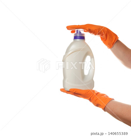 hands in rubber gloves holding a bottle with gel by the bottom and cap 140655389