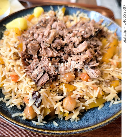 Traditional pilaf with succulent meat, chickpeas, and raisins, served on a plate. Traditional pilaf with succulent meat, chickpeas, and raisins, served on a plate. 140655607