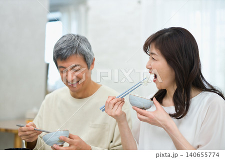 美味しそうに朝食を食べる60代の夫婦 美味しそうに朝食を食べる60代の夫婦 140655774