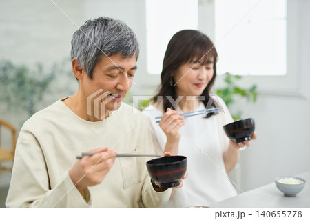 美味しそうに朝食を食べる60代の夫婦 美味しそうに朝食を食べる60代の夫婦 140655778