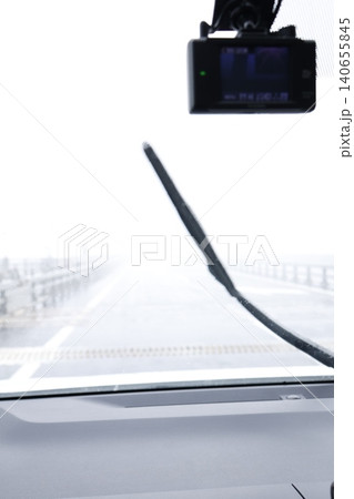 濃霧で視界不良の車内フロント。ワイパー作動中。景色がぼやけた状態 140655845
