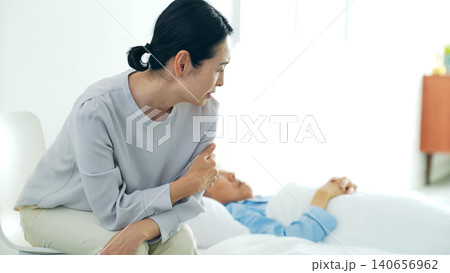 昏睡するシニア男性と悩む女性 140656962