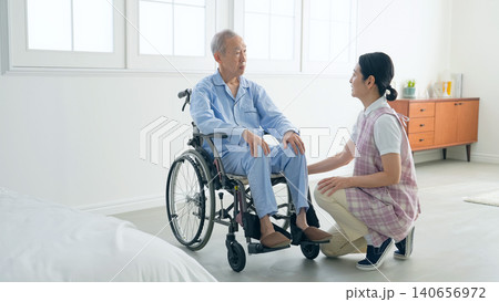車いすに乗ったシニア男性と会話する女性ケアスタッフ 140656972