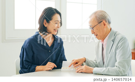 高齢男性に薬を説明する女性 140657014