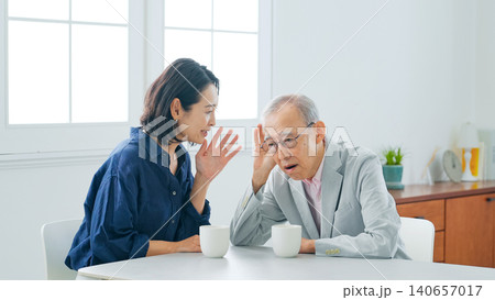 耳の遠いシニア男性と会話するミドル女性 耳の遠いシニア男性と会話するミドル女性 140657017