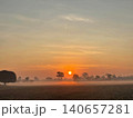 Beautiful Sunrise Over Misty Rural Landscape with Palm Tree Silhouettes 140657281