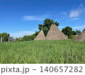 Traditional Straw Haystacks in Green Field under Blue Sky 140657282