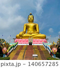 Giant Golden Buddha Statue on Lotus Pedestal at Thai Temple with Naga Stairs 140657285