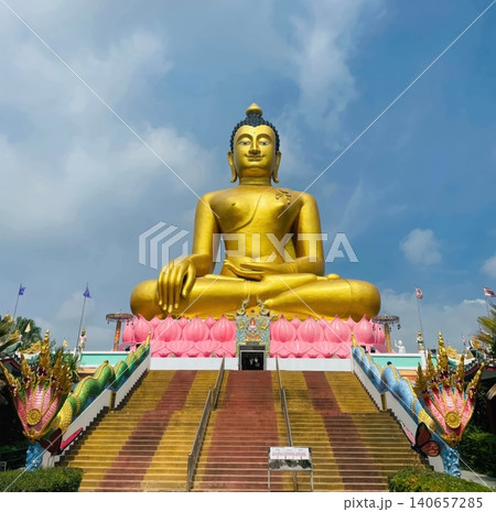 Giant Golden Buddha Statue on Lotus Pedestal at Thai Temple with Naga Stairs 140657285