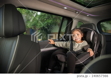 happy preschool child girl sitting in car seat, safety baby chair travelling happy preschool child girl sitting in car seat, safety baby chair travelling 140657366