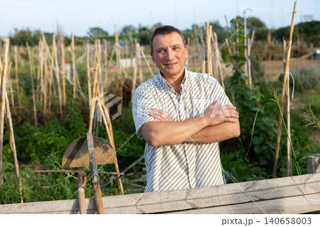 Portrait of positive man at fence 140658003