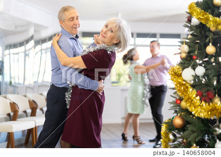 In studio decorated for New Year, elderly man and woman perky dance pair discofox. In studio decorated for New Year, elderly man and woman perky dance pair discofox. 140658004