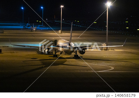 夜の空港に駐機するANA旅客機と搭乗タラップ(滑走路の灯り) 夜の空港に駐機するANA旅客機と搭乗タラップ(滑走路の灯り) 140658179