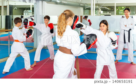 Children practicing boxing punches in pairs Children practicing boxing punches in pairs 140658191
