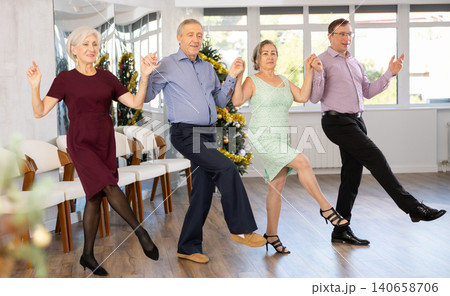 View of senior people holding hands and dancing national dance Sardana during celebration Christmas View of senior people holding hands and dancing national dance Sardana during celebration Christmas 140658706