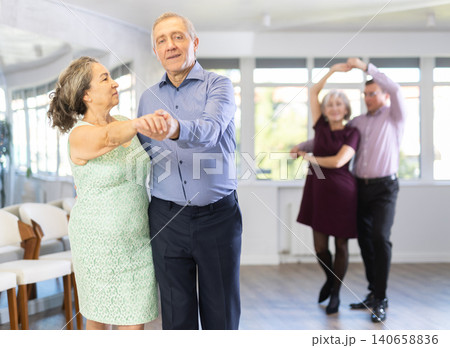 Senior man and elderly woman are dancing classic version of waltz in couple Senior man and elderly woman are dancing classic version of waltz in couple 140658836