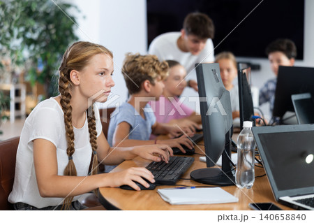 Preteen girl working with computer programs in training room Preteen girl working with computer programs in training room 140658840