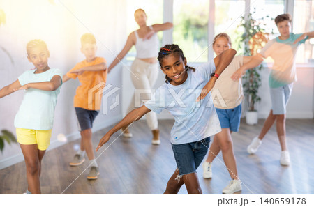 African boy dances vogue in choreographic school, friends and teacher dance in gym blurry background 140659178